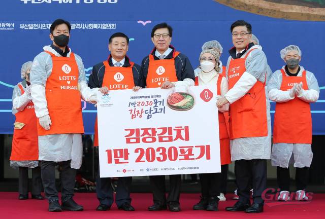 부산시가 25일 오전 9시 사직야구장 앞 광장에서 부산 지역 롯데그룹 계열사 주관으로 ‘2030 세계박람회 유치 기원 1만 2030포기 김장 담그기 행사’를 열고 지역 내 저소득층 4000여 가구에 김장을 지원할 것이라고 밝혔다. 올해는 2030 세계박람회 유치를 기원하는 의미로 1만 2030포기를 담갔다. 이석환(왼쪽 첫 번째) 롯데 자이언츠 대표와 박형준(〃세 번째) 부산시장, 서정곤(〃다섯 번째) 부산롯데호텔 대표가 기념 촬영을 하고 있다. 사진 제공=롯데지주