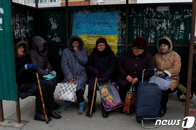 러시아 군이 우크라이나 헤르손 지역에서 물러난 가운데 여성들이 22일(현지시간) 버스정류장에서 구호품을 기다리고 있다. ⓒ 로이터=뉴스1 ⓒ News1 최종일 기자