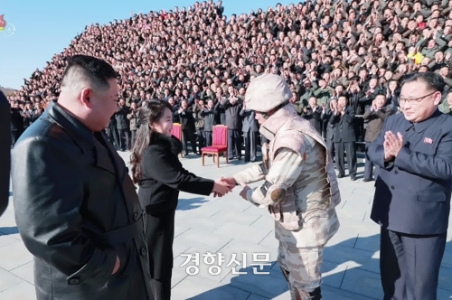‘화성-17형’ 발사 참여 공로자들과의 기념사진 촬영 핵사에 동행한 김정은 국무위원장의 둘째 딸이 군복을 입은 군 지휘관과 악수를 나누고 있다.  조선중앙TV/연합뉴스