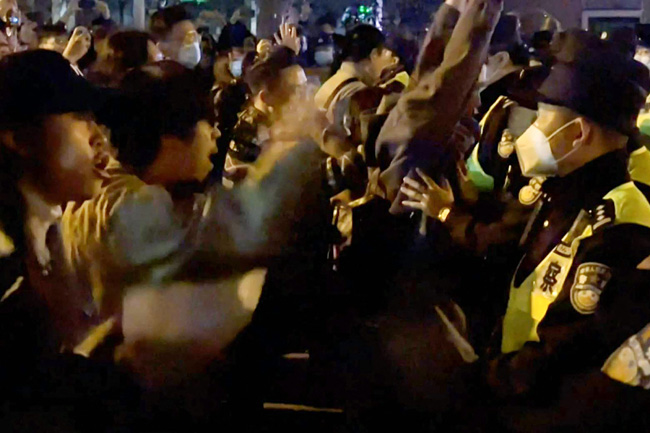 27일(현지시간) 새벽 중국 상하이 시내에서 성난 시민들이 쏟아져 나와 ‘제로 코로나’ 정책을 규탄하는 구호를 외치고 있다. AFP 연합뉴스