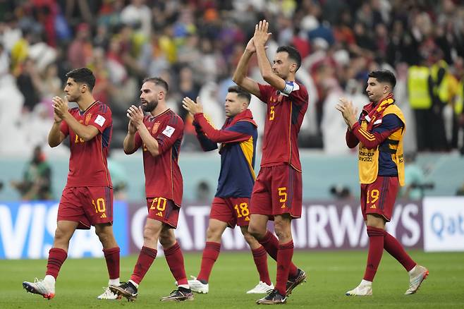 Spain's Marco Asensio, Dani Carvajal, Jordi Alba, Sergio Busquets and Carlos Soler, from left, applaud the fans at the end of the World Cup group E soccer match between Spain and Germany, at the Al Bayt Stadium in Al Khor , Qatar, Sunday, Nov. 27, 2022. The match ended in a 1-1 draw. (AP Photo/Matthias Schrader)