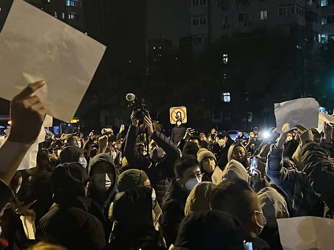27일 밤 시작된 베이징의 반(反)봉쇄 시위에서 시민들이 항의의 의미로 아무것도 적혀 있지 않은 흰 종이를 들고 있다./베이징=이벌찬 특파원