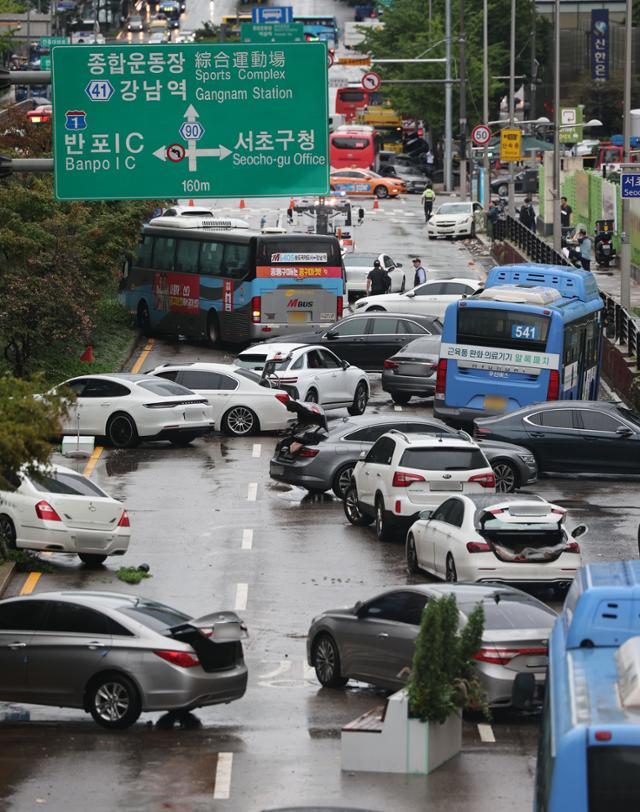 기록적 폭우가 내린 다음날인 8월 9일 서울 서초구 진흥아파트 앞 서초대로 일대에서 전날 내린 폭우에 침수됐던 차량이 모습을 드러내고 있다. 연합뉴스