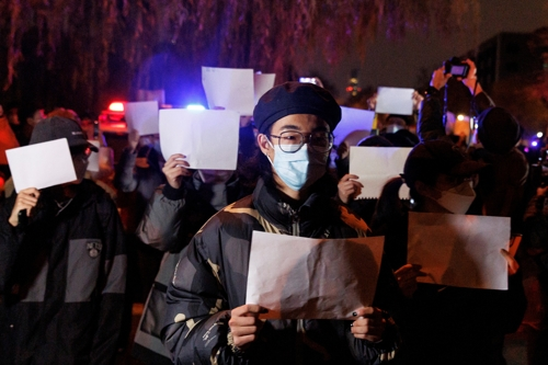 중국 수도 베이징에서 지난 27일 시민들이 신장 우루무치 참사 희생자를 추모하고 코로나19 봉쇄 조치에 항의하는 ‘백지 시위’를 하며 거리를 행진하고 있다. 로이터연합뉴스
