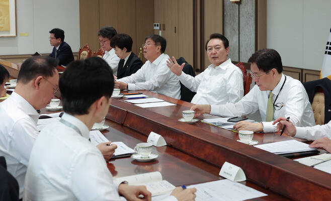President Yoon Suk-yeol (second from right, opposite side) speaks during a meeting with presidential office secretaries at his office in Yongsan-gu district on Monday. (The Presidential Office)