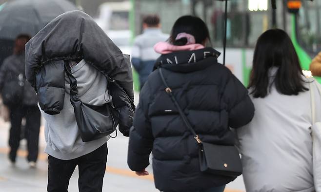 전국 곳곳 비가 예보된 28일 서울 광화문광장 인근에서 시민이 겉옷으로 비를 막으며 이동하고 있다. 연합뉴스