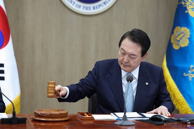 President Yoon Suk-yeol hits a gavel as the Cabinet meeting commenced Tuesday. (The Presidential Office)