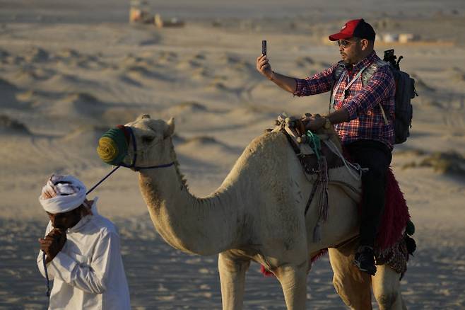 한 관광객이 낙타를 타고 셀피를 남기고 있다.(사진=AP/뉴시스)