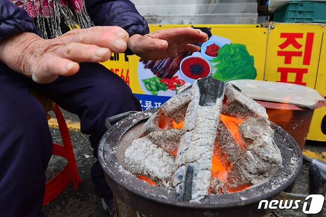 전국에 한파경보가 발효된 30일 오전 경북 포항시 죽도어시장에서 상인들이 화로에 손을 녹이고 있다.2022.11.30/뉴스1 ⓒ News1 최창호 기자