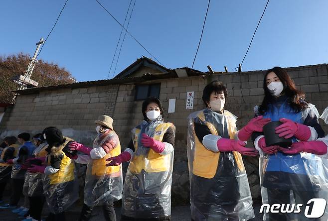 30일 오후 서울 노원구 상계동 일대에서 고려아연 임직원들과 적십자 봉사원들이 취약계층에게 전달할 연탄을 나르고 있다. 2022.11.30/뉴스1 ⓒ News1 송원영 기자