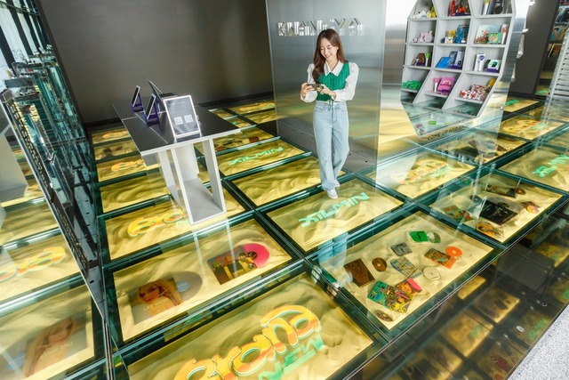 SM브랜드마케팅의 플래그십스토어 '광야@서울'을 방문한 고객이 LG디스플레이 투명 OLED 33대로 구성된 '투명 OLED 플로어 솔루션'을 경험하고 있다. /LG디스플레이 제공