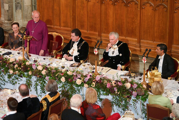 영국 성공회의 캔터베리 대주교 저스틴 웰비가 28일(현지시각) 런던 길드홀의 행사에서 일어서 연설하고 있다. 맨 오른쪽은 리시 수낵 총리. 로이터 연합뉴스