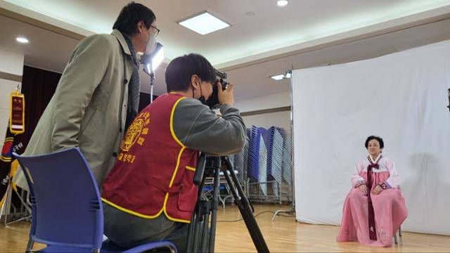 청주대 연극영화학부 학생들이 청주시 서원구 분평동 주민센터에 촬영 세트장을 꾸려놓고 어르신 사진을 찍고 있다. 이 학부생들은 2012년부터 재능 기부로 '행복한 장수사진' 촬영 봉사를 하고 있다. 청주대 제공