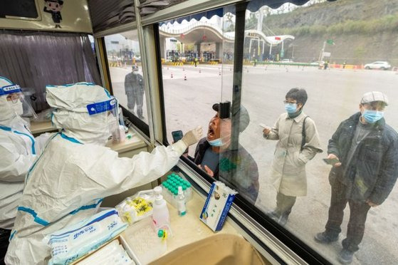 지난달 14일(현지시간) 중국 저장성에서 방역 당국자들이 코로나19 검사를 하고 있다. [로이터=연합뉴스]