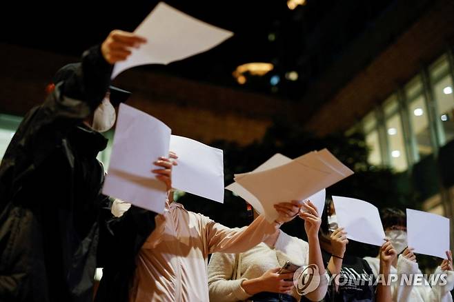 '제로 코로나' 반대시위 현장서 백지 나눠주는 홍콩 여성들 (홍콩 로이터=연합뉴스) 29일(현지시간) 중국 홍콩 홍콩대에서 열린 우루무치 화재 사건 피해자 추도식에서 여성들이 중국 정부의 코로나19 규제에 반대하는 시위를 벌이려고 백지를 나눠주고 있다. 지난 24일 신장 우루무치의 고층 아파트에서 발생한 화재 사건 당시 각종 봉쇄용 장치들이 진화를 방해했다는 의혹이 제기된 이후 중국 곳곳에서 사람들이 흰 종이를 펴든 채 '제로 코로나' 정책에 반대하는 '백지 시위'를 벌이고 있다. 2022.11.30 ddy04002@yna.co.kr