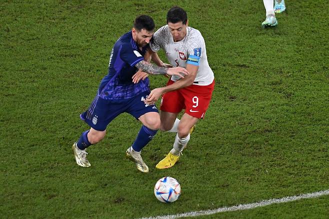 아르헨티나의 리오넬 메시(왼쪽)와 폴란드의 로베르트 레반도프스키가 1일 카타르 도하의 구칠사(974) 스타디움에서 열린 2022 월드컵 C조 조별리그 3차전에서 몸싸움을 하고 있다. /AFP연합뉴스