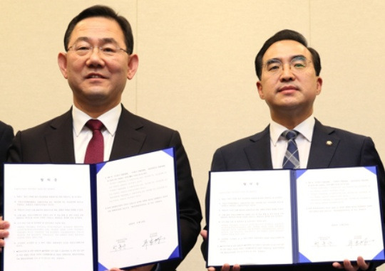 People Power Party floor leader Joo Ho-young and Democratic Party of Korea floor leader Park Hong-keun hold up an agreement between the two parties on a parliamentary inspection of the Itaewon crowd crush in the National Assembly on November 23. Yonhap News