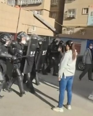 A woman is seen standing in front of police in a video. (Twitter @whyyoutouzhele)