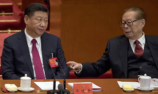 지난 2017년 10월 24일 베이징에서 열린 제19차 당대회 폐막식에서 장쩌민(오른쪽) 전 중국 국가주석이 시진핑 중국 국가주석의 팔을 두드리고 있다. AP연합뉴스