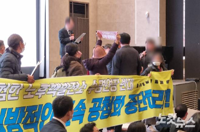 2일 부산 남구에서 열린 고리2호기 계속 운전 관련 방사선환경영향평가서 초안 공청회장에서 환경단체 회원(현수막 주변)들이 반발하는 가운데 한수원 관계자(단상 맨 위)가 공청회를 진행하고 있다. 박진홍 기자