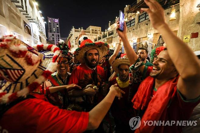 '36년 만에 16강 진출'에 환호하는 모로코 축구 팬들 (도하 AFP=연합뉴스) 1일(현지시간) 모로코 축구 국가대표팀이 2022 카타르 월드컵 조별리그 F조 3차전 캐나다와의 경기에서 2-1로 승리한 후 모로코 축구 팬들이 카타르 도하 수크 와키프 시장에서 환호하고 있다. 이번 월드컵에서 같은 조 크로아티아와 벨기에에 상대적 약체로 평가됐던 모로코는 조별리그에서 2승 1무(승점 7)를 기록, 조 1위로 16강에 진출했다. 벨기에의 16강 진출은 1986년 이후 36년 만이다. 2022.12.02 jason3669@yna.co.kr