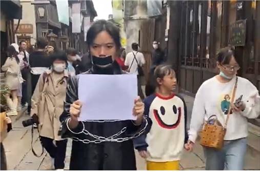 <11월 27일 저장(浙江) 우전(烏鎭)의 관광지에서 한 시민이 백지 혁명을 선전하는 퍼포먼스를 연출하고 있다. 사진/https://twitter.com/wurenhua>