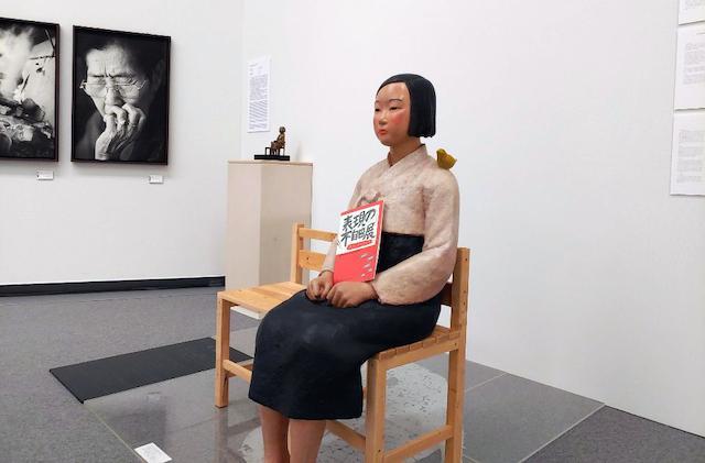 2019년 8월 일본 아이치현 나고야시 아이치현문화예술센터에서 열린 '아이치현 트리엔날레' 기획전 '표현의 부자유전: 그 후'에 전시된 평화의 소녀상 손에 '표현의 부자유전' 팸플릿이 들려 있다. 나고야=연합뉴스