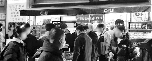 지난 2일 포르투갈과의 월드컵 축구 경기를 앞두고 야외 응원에 나선 시민들이 서울 광화문 인근 편의점 CU에서 핫팩과 먹거리를 구입하고 있다.  CU 제공