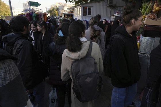 지난달 14일 이란 여성들이 이란 수도 테헤란의 번화가를 히잡을 쓰지 않은채 활보하고 있다. AP=연합뉴스