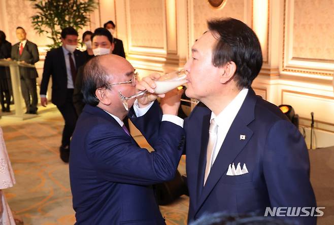 [서울=뉴시스] 전신 기자 = 윤석열 대통령이 5일 청와대 영빈관에서 열린 국빈만찬에서 응우옌 쑤언 푹 베트남 국가주석과 함께 전통주를 마시고 있다. (대통령실통신사진기자단). 2022.12.05. photo1006@newsis.com