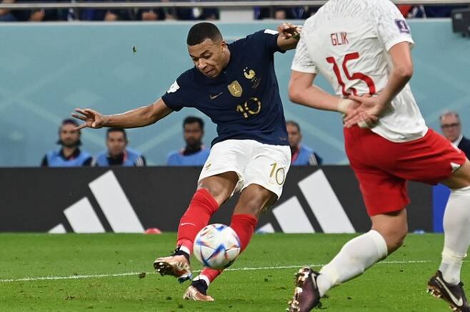 프랑스 축구대표팀 킬리안 음바페가 5일 카타르 도하 알투마마 스타디움에서 열린 2022 카타르 월드컵 16강전 폴란드와 경기에서 슈팅하고 있다. 이 슈팅은 골문으로 들어가 2-0을 만든 프랑스의 두번째 골이 됐다. 도하 | AFP연합뉴스