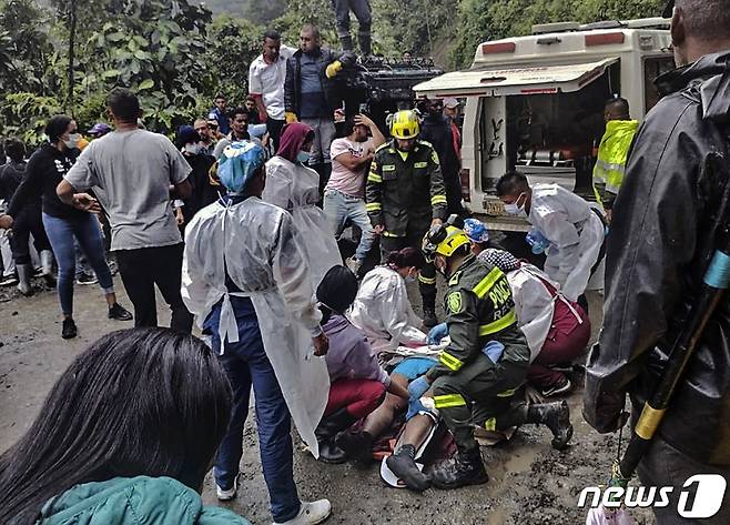 4일(현지시간) 콜롬비아 푸에블로 리코에서 산사태가 발생해 버스와 오토바이가 묻힌 현장서 구조대원이 생존자를 구급차에 싣고 있다. ⓒ AFP=뉴스1 ⓒ News1 우동명 기자