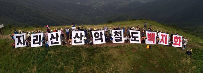 지리산 산악열차에 반대하는 시민단체 ‘반달곰친구들’ 회원들이 사업 추진의 백지화를 요구하는 손팻말을 들고 있다. 반달곰친구들 제공