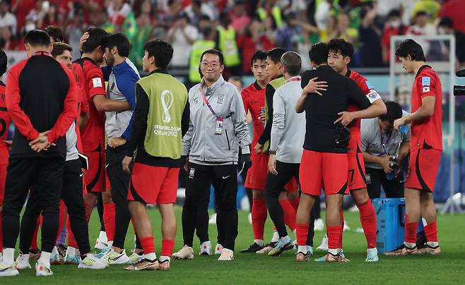 South Korean national team captain Son Heung-min (second from right) embraces his teammate after they were eliminated by Brazil in a match held at the Education City Stadium in Al Rayyan, Qatar, on Tuesday, Korean Time. (Yonhap)