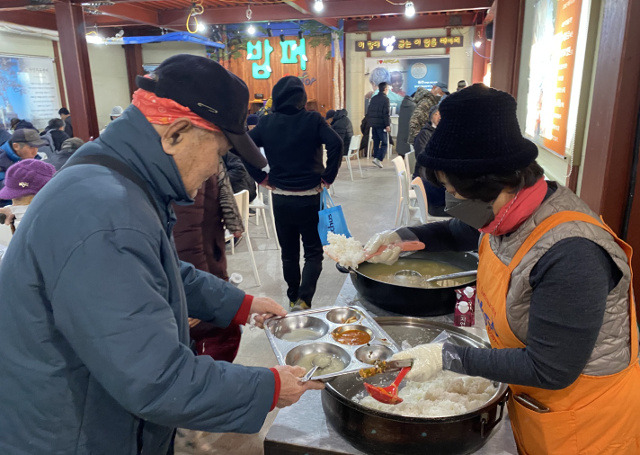 다일공동체 자원봉사자(오른쪽)가 최근 서울 동대문구 밥퍼나눔운동본부를 찾은 어르신에게 무료 배식을 하고 있다. 다일공동체 제공