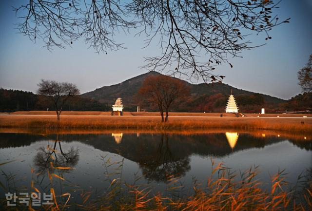 익산 미륵사지에 어둠이 내리자 경관 조명을 밝힌 동·서 두 개의 탑이 연못에 비치고 있다. 백제 무왕 때 건립한 미륵사는 국내 최대 규모의 사찰로 평가된다.