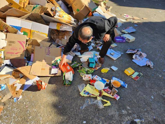 정윤섭 한국제지원료재생업협동조합 전무이사가 지난 2일 경기 남양주시의 한 폐지 압축장에 쌓인 폐지 더미에서 재활용을 어렵게 만드는 불순물을 골라내고 있다. 곽주현 기자