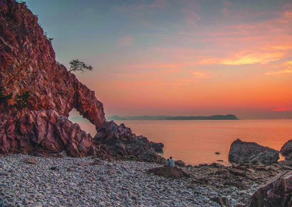 충남 서산시 대산읍 독곶리 황금산 해변에 다정하게 앉은 연인이 저녁노을에 물든 바다와 코끼리바위를 감상하고 있다. 가로림만 건너 만대항 등이 자리한 태안 땅이 서해로 길게 뻗어 있다.