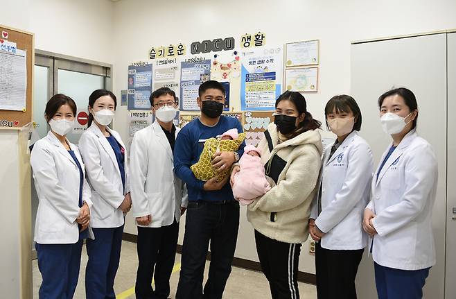 [수원=뉴시스] 태국 국적의 산모 부부와 쌍둥이 자녀들이 의료진과 함께 기념사진을 찍고 있다. (사진=아주대병원 제공) 2022.12.07. photo@newsis.com *재판매 및 DB 금지