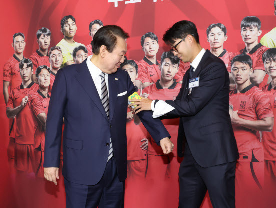 8일 청와대 영빈관에서 열린 축구 국가대표팀 환영 만찬에서 주장 손흥민 선수가 2022 카타르 월드컵 기간 착용했던 주장 완장을 윤석열 대통령에게 채워주고 있다. (사진=연합뉴스)