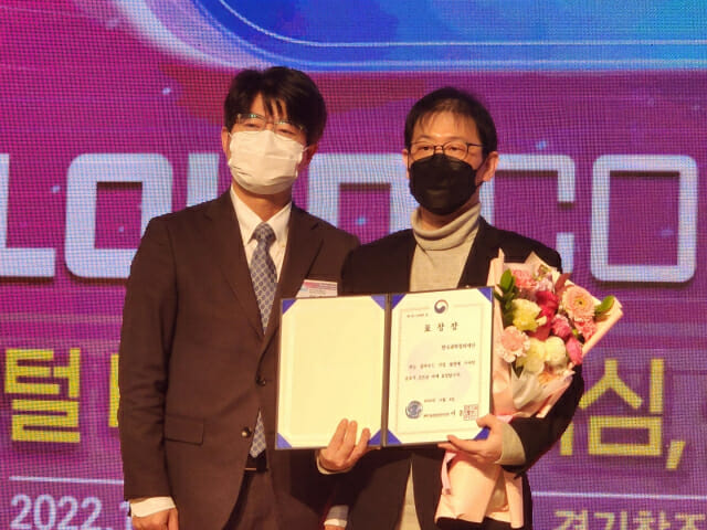 한국과학창의재단 김진만 팀장(오른쪽)이 엄열 과기정통부 인공지능정책관에게서 장관 표창상을 받고 있다.