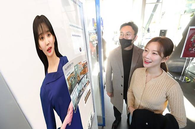 KT 모델이 노보텔 앰배서더 서울 동대문 호텔＆레지던스 1층 로비에 설치된 ‘AI 컨시어지’ 앞에서 호텔 서비스 안내를 받고 있다.ⓒKT