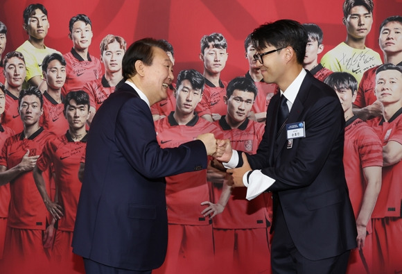 주장 완장 선물받은 윤석열 대통령-8일 청와대 영빈관에서 열린 축구 국가대표팀 환영 만찬에서 윤석열 대통령이 주장 손흥민 선수로부터 2022 카타르 월드컵 기간 착용했던 주장 완장을 선물받은 뒤 주먹을 맞대고 있다. 2022.12.8 연합뉴스