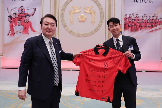'16강 진출 국민과 함께 축하합니다' 윤석열 대통령이 8일 청와대 영빈관에서 열린 축구 국가대표팀 환영 만찬에서 손흥민 선수에게 '카타르 16강 진출 국민과 함께 축하합니다'라고 적은 유니폼을 전달하고 있다. 2022.12.8 [대통령실 제공, 재판매 및 DB 금지]<저작권자(c) 연합뉴스, 무단 전재-재배포 금지>