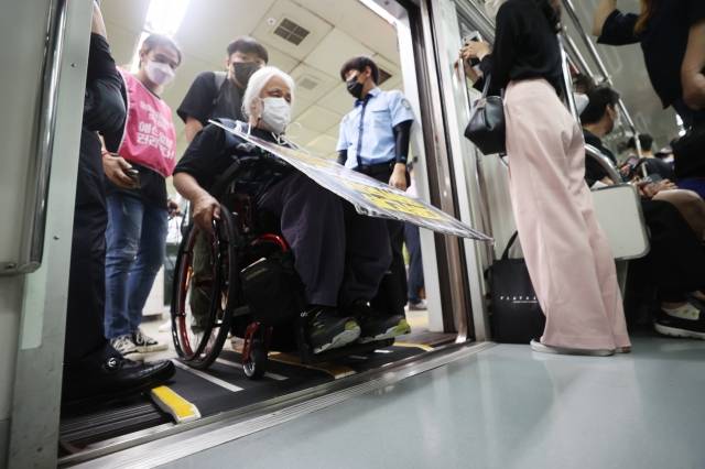 박경석 전국장애인차별철폐연대(전장연) 대표가 지난 9월 13일 오전 서울 5호선 광화문역에서 장애인권리예산 삭감을 규탄하며 지하철에 탑승하고 있다. 연합뉴스