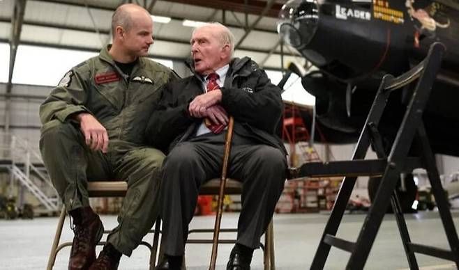 2차대전 참전용사 조지 존슨(오른쪽)이 지금도 존재하는 영국 공군 617비행대대를 방문해 까마득한 후배 조종사와 대화하는 모습. 게티이미지 제공