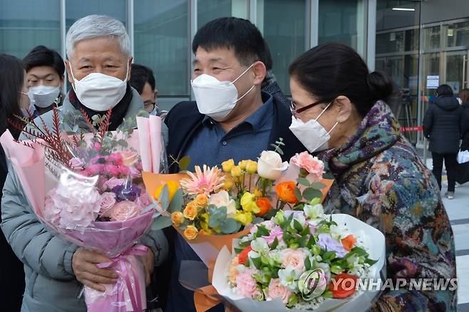 지인들의 축하받은 윤성여 씨 (서울=연합뉴스) 17일 오후 경기도 수원시 영통구 수원지방법원에서 열린 이춘재 연쇄살인 8차 사건 재심 선고공판에서 재심 청구인 윤성여 씨가 무죄를 선고받고 법원 청사를 나와 지인들의 축하를 받고 있다. 2020.12.17 [사진공동취재단] photo@yna.co.kr