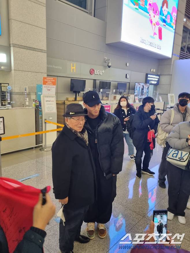 ◇황희찬 할아버지와 사진 찍는 백승호. 사진(인천공항)=윤진만 기자