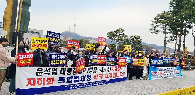 군포시민들 "당정역∼서울역 지하화 " 요구     (군포=연합뉴스) '당정역∼서울역 지하화 군포시범시민추진위원회'는 10일 서울 용산 대통령실 맞은편 전쟁기념관 앞에서 집회를 열고 즉각적인 경부선 지하화를 요구했다.
 군포시민 등 집회 참가자들이 플래카드와 현수막을 들고 있는 모습. 2022.12.10 [군포시범시민추진위원회 제공. 재판매 및 DB 금지] hedgehog@yna.co.kr