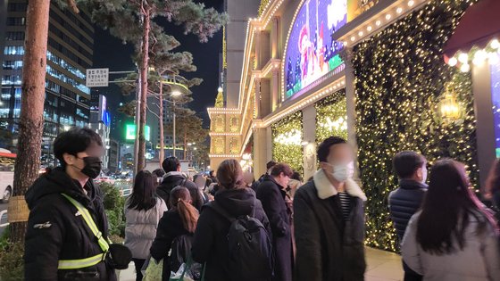 9일 오후, 서울 중구 롯데백화점 본점 크리스마스 트리 앞에서 시민들이 사진을 찍는 가운데 안전요원이 통행로를 확보하고 있다. 최서인 기자.